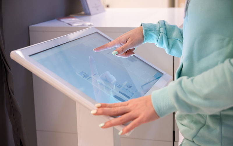 Faceless woman touching the screen of a self-service device in a store. Device store navigator. Self purchase