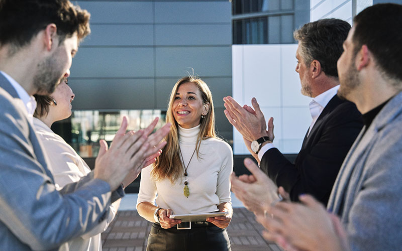 group of businessmen at a meeting or business plan exhibition applauding a middle-aged woman who was the event's sponsor
