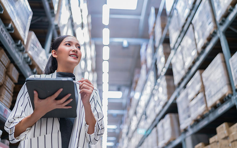 asian female business owner using digital tablet checking amount of stock product inventory on shelf at distribution warehouse factory.logistic business shipping and delivery logistic service